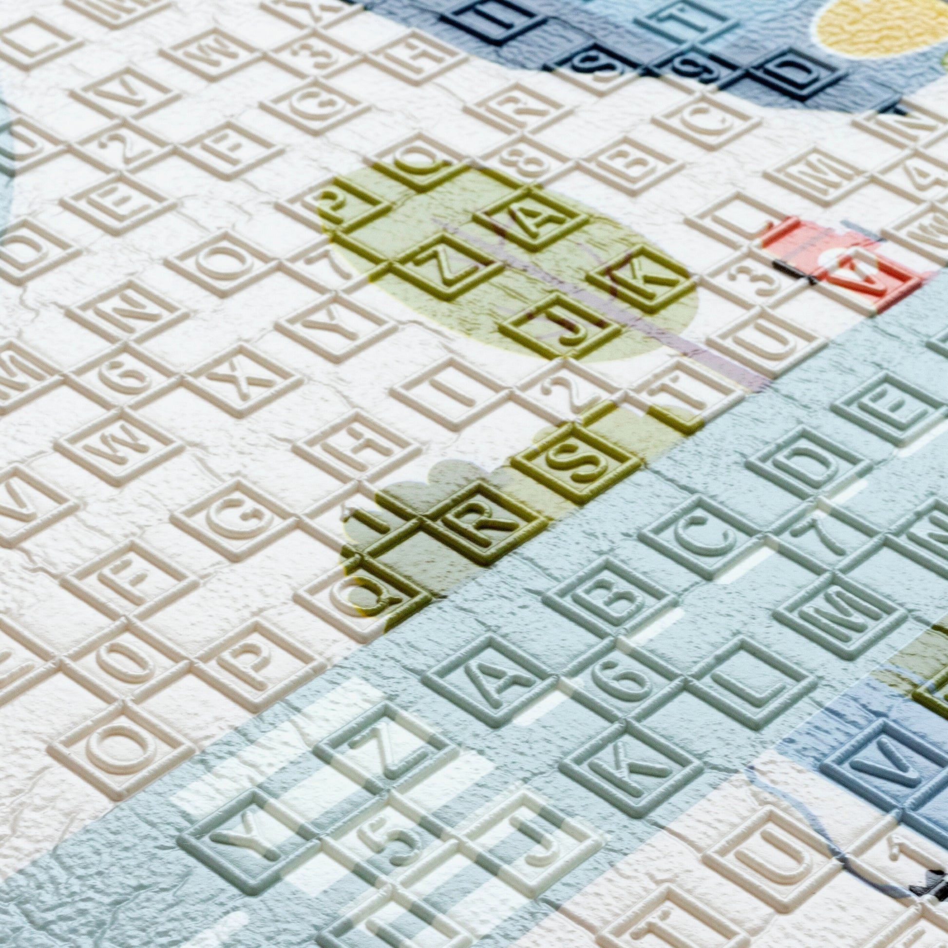  a soft-textured kids playmat featuring an ABC pattern. The letters are colorful and raised, adding a sensory element, with a cushioned surface providing comfort and tactile stimulation.